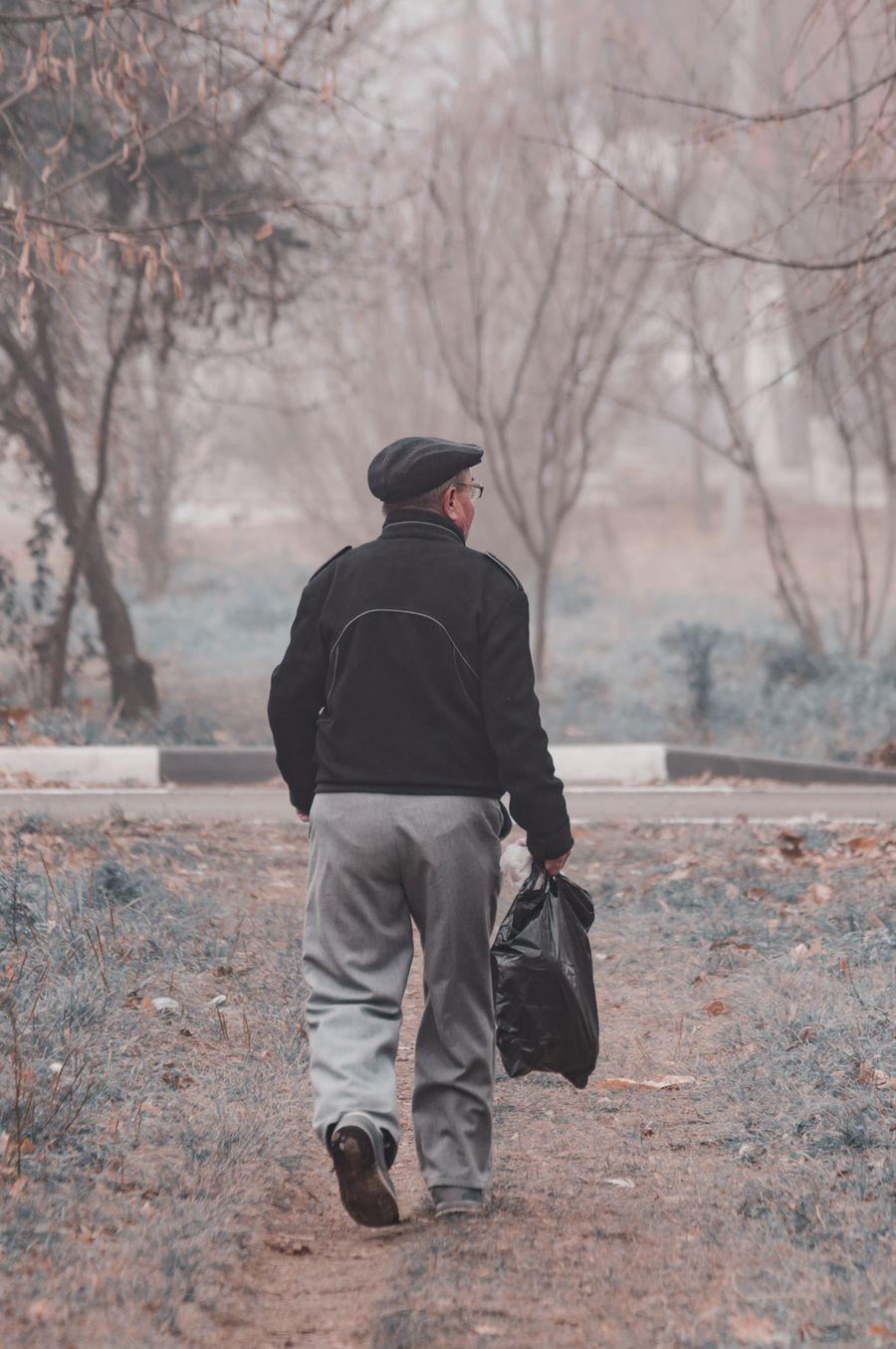 Homme qui marche dans une allée bordée d’arbres