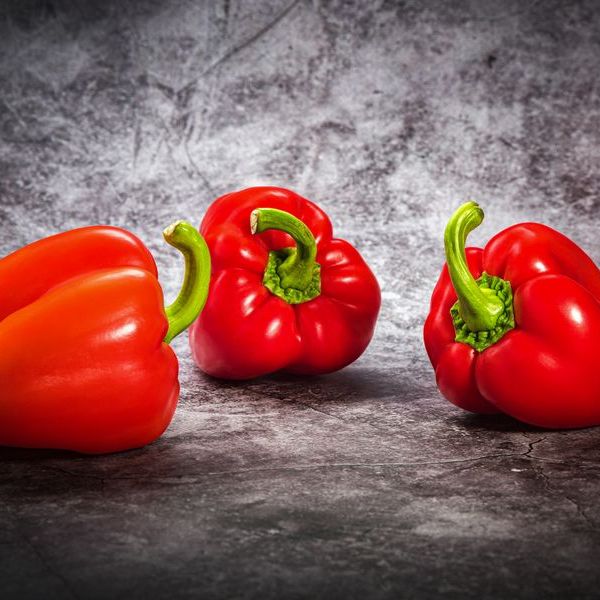 Trois poivrons rouges sur une surface en pierre