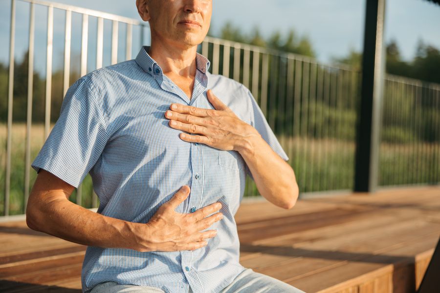 Homme qui respire calmement, une main sur la poitrine et l’autre sur le ventre