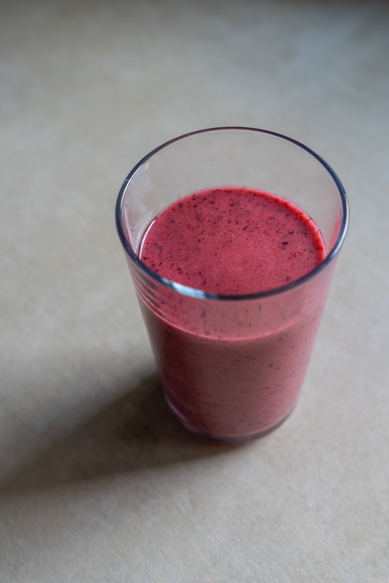 Verre de smoothie violet aux fruits rouges