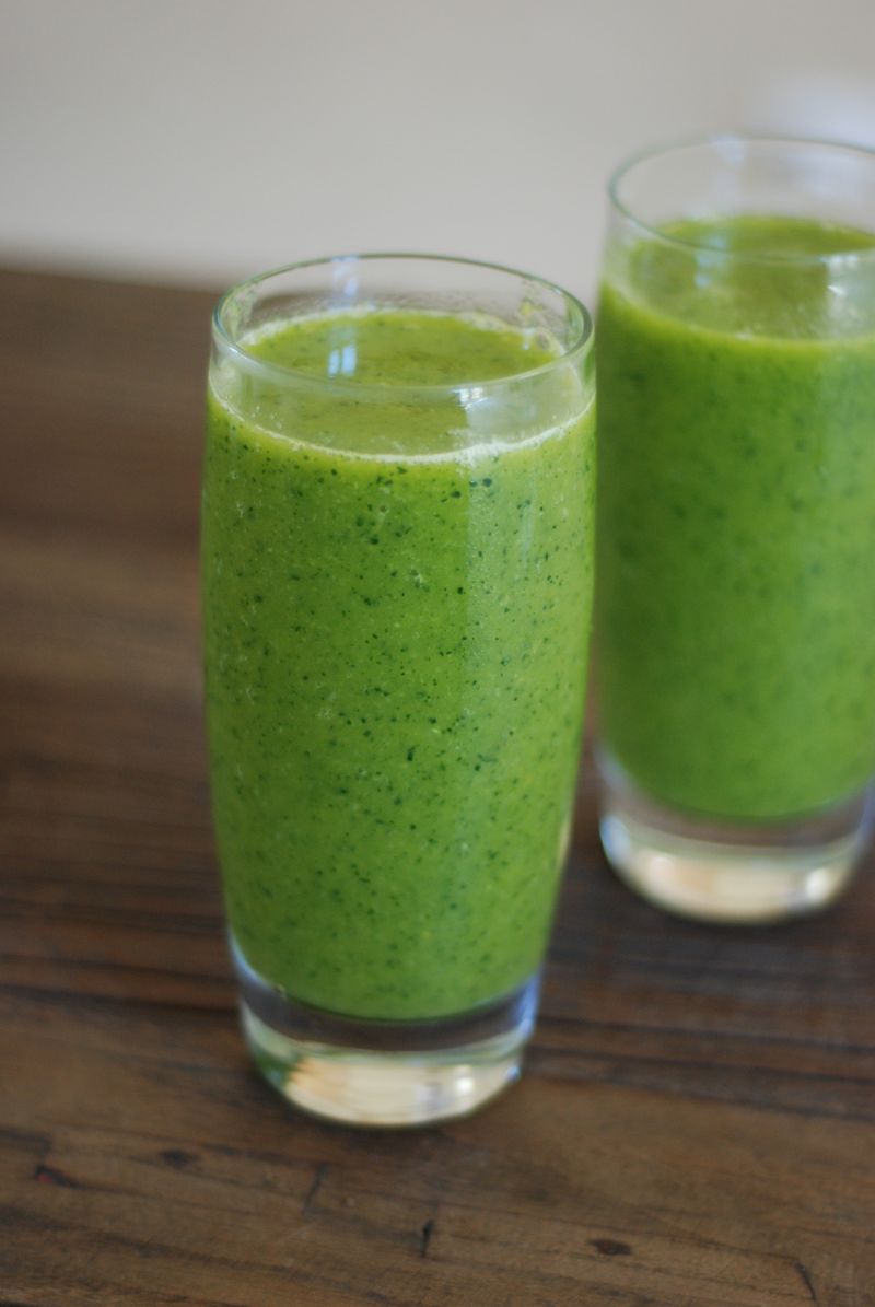 Deux verres de smoothie vert sur une table en bois